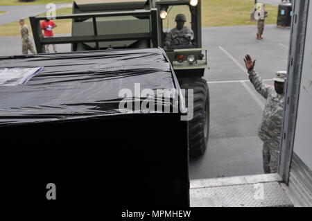 PERRY MESSEGELÄNDE, Perry, Ga, 29. März 2017 - Georgia Armee nationale Scots Guards Staff Sgt. Garrette Hall, ein petroleumversorgung Fachmann mit der 201St Region Support Group, Boden führt den Gabelstapler Fahrer als Pakete aus der Nutzfahrzeuge während Wachsam Guard 17 verschoben werden. Die Fahrzeuge, die Ausrüstung, die notwendig ist, um Vorsorge für den Fall eines katastrophalen Ereignisses. (U.S. Army National Guard Foto von Kiara Schweiß/Freigegeben) Stockfoto