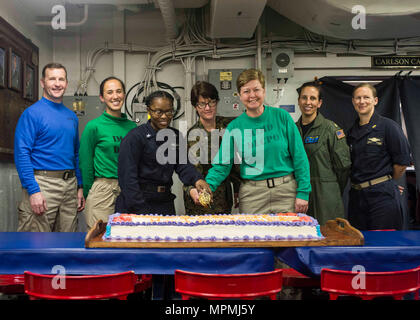 Indischer Ozean (30. März 2017) USS Makin Island (LHD 8) befehlshabenden Offizier, Kapitän Mark A. Melson verbindet Segler für einen Kuchen schneiden nach dem Monat Geschichte der Frauen feiern. Makin Island, das Flaggschiff der Makin Island amphibischen bereit, mit der begonnen 11 Marine Expeditionary Unit, arbeitet in der Indo-Asia-pazifischen Region amphibische Fähigkeit mit regionalen Partnern zu verbessern und als gebrauchsfertige Response Force für jede Art der Kontingenz zu dienen. (U.S. Marine Foto von Mass Communication Specialist 3. Klasse Eric Zeak) Stockfoto