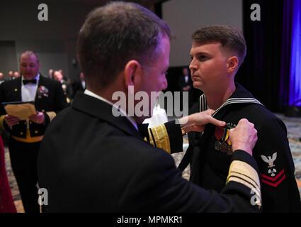 170401-N-TP 832-203 Jekyll Island, Ga (April. 1, 2017) Vice Adm. Joseph Tofalo, Commander, Submarine Kräfte, Stifte einen eingetragenen U-Boot-Krieg Qualifikation Gerät auf der Machinist Mate 2. Klasse Seth's Dobson einheitliche an der Naval Submarine Base der Kings Bay 117 U-Boot Geburtstag Ball an der Jekyll Island Convention Center. (U.S. Marine Foto von Mass Communication Specialist 3. Klasse Michael Lopez/Freigegeben) Stockfoto