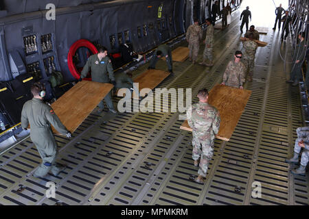 Soldaten und Piloten sperrholz Entladen für Luft Ausbildung März 28, 2017 Hunter Army Airfield, Ga. Das Sperrholz ist eine Barriere zwischen Flugzeug der C5 Super Galaxy' und der Abrams Panzer und Bradley, die Bekämpfung der Fahrzeuge des 2nd Battalion, 7th Infantry Regiment, 1st Armored Brigade Combat Team, 3rd Infantry Division. Soldaten von 2-7. Inf. Bilden die unmittelbare bereit, Firma, die behauptet, die Bereitschaft der Global Response Force innerhalb von 18 Stunden nach der Benachrichtigung zu unterstützen. (U.S. Armee Foto: Staff Sgt. Candace Mundt/Freigegeben) Stockfoto