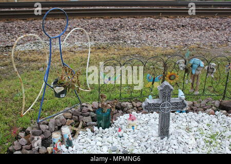 Am Straßenrand Denkmal für einen verlorenen Geliebten umfasst Engel, Kreuze und Schnickschnack. Stockfoto