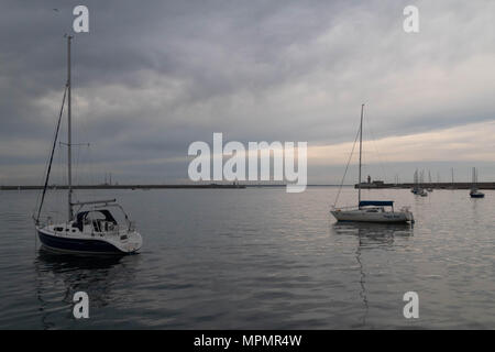 Sonnenuntergang in Dun Laoghaire Hafen, Segelboote, sanfte Farben, ruhiges Meer Oberfläche Stockfoto