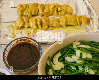 Indonesische Essen, für das Abendessen vorbereitet. Schiefe Hühnersaté auf vereitelt Fach, Erdnuß-Sauce, kecap masin Sauce und grüne Bohnen mit Gurkensalat Stockfoto