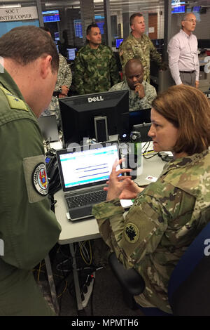 Die kolumbianische Luftwaffe Oberstleutnant Ernesto Gomez (links) erläutert die Anforderungen für militärische Unterstützung sind mit Georgien Army National Guard Chief Warrant Officer 3 Julie Glücksspiel an der Georgia Emergency Management Agency in Atlanta, Ga. verarbeitet, während einer Tour von der State Emergency Operations Center, 30. März 2017. Gomez, und vier anderen kolumbianischen Militärs, verbrachten die Woche Touring mehrere Spielstätten während der Wachsam Guard Übung mit der South Carolina National Guard als Teil des Staates. (U.S. Air National Guard Foto von 1 Leutnant Stephen Hudson/Freigegeben) Stockfoto
