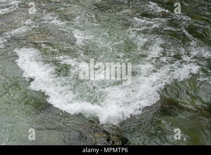Wasser im Fluss von Bergsee fließt über Felsen im Fluss verursachen Turbulenzen und Schaumbildung Stockfoto