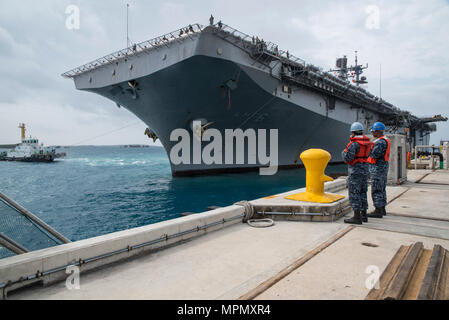 170406-N-XT 039-110 Okinawa, Japan (6. April 2017) Fachkraft für Lagerlogistik Seemann Angel Acevedo, vorne, von San Juan, Puerto Rico, zugeordnet zu den amphibious Transport dock USS Green Bay LPD (20), und der bootsmann Mate 3. Klasse Tajh Parkins, von Louisville, Ky., Commander, Flotte Aktivitäten Okinawa (Cfao) Port Operations zugeordnet, die Handhabung Aufgaben durch, wie die amphibious Assault ship USS BONHOMME RICHARD (LHD 6) pierside am weißen Strand Marinestützpunkt ankommt Marines an Bord der 31 Marine Expeditionary Unit. Bonhomme Richard, dem Flaggschiff der Bonhomme Richard amphibischen Bereit Gro Stockfoto