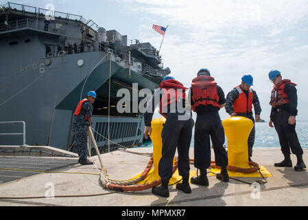 170406-N-XT 039-110 Okinawa, Japan (6. April 2017) Pierside line-Handler Moor die Amphibious Assault ship USS BONHOMME RICHARD (LHD6) während der Ankunftszeit des Schiffes zu weißen Strand Marinestützpunkt Marines an Bord der 31 Marine Expeditionary Unit. Bonhomme Richard, dem Flaggschiff der Bonhomme Richard amphibischen bereit, Gruppe, ist auf eine Patrouille, die in der Indo-Asia - Pazifik Region warfighting Bereitschaft und Haltung als ready-Response Force für jede Art der Kontingenz zu verbessern. (U.S. Marine Foto von Mass Communication Specialist Seaman Jesse Marquez Magallanes/Freigegeben) Stockfoto