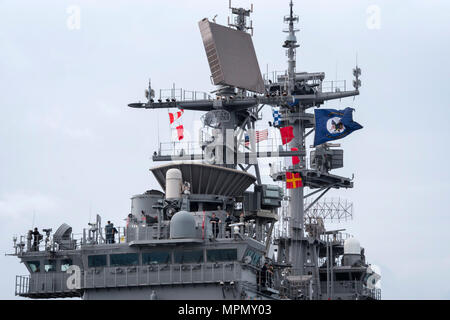 170406-N-WF 272-008 WHITE BEACH, Okinawa (6. April 2017) Die Amphibious Assault ship USS BONHOMME RICHARD (LHD6) fliegt seine Farben, die Revolutionäre Gator, wie sie in der Weißen Strand Marinestützpunkt für eine 31 Marine Expeditionary Unit offload ankommt. Bonhomme Richard, dem Flaggschiff der Bonhomme Richard amphibischen bereit, Gruppe, ist auf eine Patrouille, die in der Indo-Asia - Pazifik Region warfighting Bereitschaft und Haltung als ready-Response Force für jede Art der Kontingenz zu verbessern. (U.S. Marine Foto von Mass Communication Specialist 2. Klasse Diana Quinlan/Freigegeben) Stockfoto