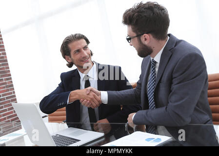 Handshake business Mann sitzt hinter einem Schreibtisch. Stockfoto