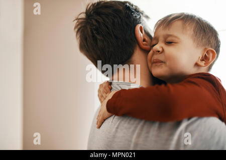 Portrait von Kleinkind sein Vater umarmt Stockfoto