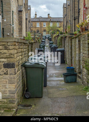 Reihen von grünen Wheelie bins säumen die Gassen zwischen Reihenhäuser in Saltaire, Yorkshire. Stockfoto