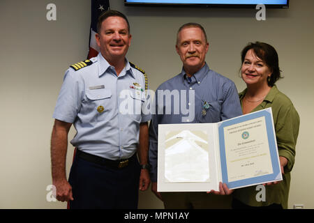 Kapitän Brendan McPherson, Stabschef, Coast Guard 13. Bezirk, steht neben Chris Feld und seine Frau nach award Feld die verdienstvolle Public Service Award, April 6, 2017. Diese Auszeichnung ist die höchste Ehre für Bürger, Gruppen oder Organisationen gegeben, die Küstenwache, zu erkennen, dass produziert greifbare Ergebnisse und einzigartige Vorteile für die Öffentlichkeit zur Verfügung stellen. U.S. Coast Guard Foto von Petty Officer 2. Klasse Ali Flockerzi. Stockfoto