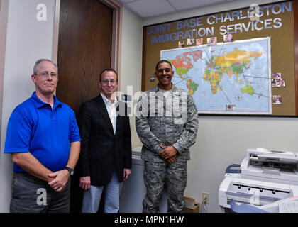 Robert Yancey, Links, 628Th Air Base Wing Büro des Personal Judge Advocate Angestellte entlassen, Brad Stanley, Mitte, 628Th ABW JA Zivilrecht Division Chief und Staff Sgt. William Haston, rechts, 628Th ABW JA NCO der Militärjustiz, präsentieren Fotos von ein paar der Leute, die sie dazu beigetragen haben, die staatsbürgerschaft Hier bekommen, 13. April 2017. Mitglieder der 628th ABW JA geholfen, mehr als 300 Mitglieder und ihre Familien ihre Staatsbürgerschaft erhalten, da die gemeinsame Basis Charleston Einwanderung Klinik im Jahr 2008 erstellt wurde. Stockfoto