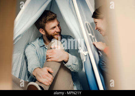 Glückliches Paar zu Hause camping ina Hütte im Wohnzimmer Stockfoto