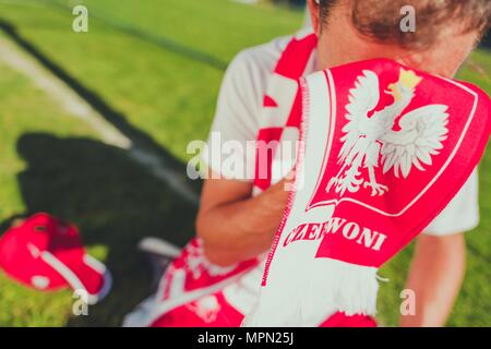 Weinend polnische Fußball-Fan. Verlorene Match Thema. Kaukasische Fußballfan bedeckte sein Gesicht durch nationale Team Rot und weißen Schal mit polnischen Embleme. Stockfoto