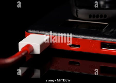 Schwarz und Rot Power Bank Ladegerät mit 2 Ausgang auf schwarzem Glas Oberfläche Stockfoto