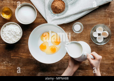 7/8 Schuß von Frau mischen Eier und Milch für Gebäck Stockfoto