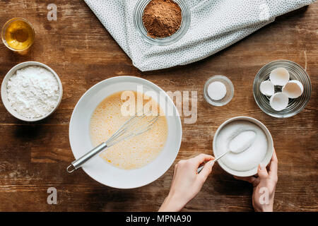 7/8 Schuß von Frau Mischen von Zutaten für Backwaren auf hölzernen Tisch Stockfoto