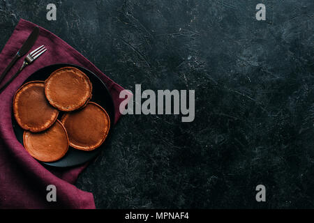 Blick von oben auf die Platte von Schokolade Pfannkuchen am schwarzen Oberfläche Stockfoto