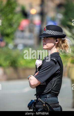 Ein Polizist mit einem Herzen zu ihrem Funkgerät verbunden steht außerhalb der Kathedrale von Manchester vor dem nationalen Service des Gedenkens in Erinnerung an die Opfer der Arena Bombenattentat in Manchester, Großbritannien, am 22. Mai 2018. Prinz William und der britische Premierminister Theresa May zusammen mit anderen Politikern, sowie Angehörige der Getöteten, und Rettungskräfte zur Szene des Terror Angriff, während Tausende von Menschen in Manchester Dienstag versammelten sich am ersten Jahrestag des Terrorangriffs in der Stadt die 22 Toten. Stockfoto