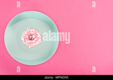 Blick von oben auf die verglaste Donut mit Marshmallow auf der Platte isoliert auf Rosa Stockfoto