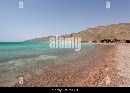 Einsame Strände an der Blauen Lagune (Dahab), Sinai, shanty Hütten Ägypten's Tourist im Hintergrund Stockfoto