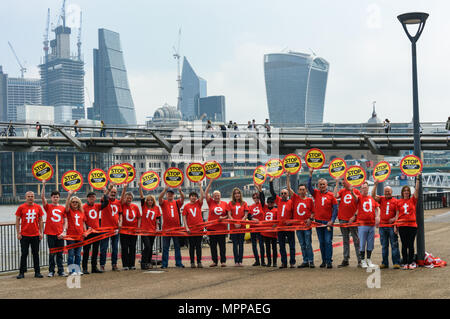 London, Großbritannien. 24. Mai 2018. Die Befürworter von Camden vereinen Gemeinschaft posieren für ein Foto auf dem Spaziergang am Flussufer in der Tate Modern, mit der Millennium Bridge und die Wolkenkratzer im Hintergrund als Teil der Unite nationalen Tag der Aktion gegen Universal Kredit. Credit: Peter Marschall/Alamy leben Nachrichten Stockfoto