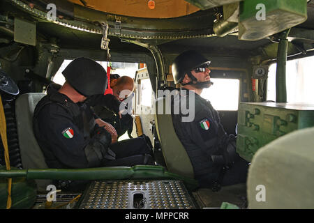 Italienischen Carabinieri der 7 Regiment "Carabinieri" leifers Bozen und 13 Regiment Carabinieri "Friuli Venezia Giulia" görz mit der High Mobility Multipurpose Radfahrzeug (Hmmwv) Ausstieg Hilfe Trainer (Wärme), bei Caserma Ederle Vicenza, Italien, 6. April 2017, Durchführen der Schulung. Der Simulator ermöglicht die Soldaten verlassen Fahrzeuge, Fähigkeiten zu üben und in realistischen Szenarien. Carabinieri mit US-Armee RTSD Süden Ausrüstung, um die bilateralen Beziehungen zu verbessern und die Zusammenarbeit und die Kapazität des Personals in gemeinsamen Aktionen beteiligt zu erweitern. (U.S. Armee Foto von Vi Stockfoto