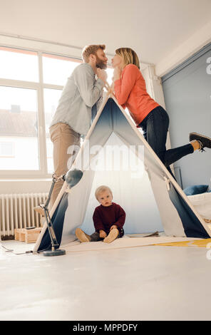 Glückliches Paar über Zelt mit ihrem Sohn sitzen küssen Stockfoto