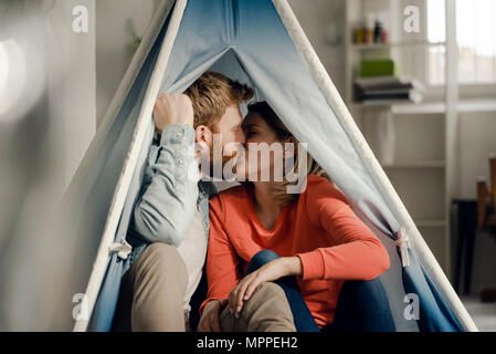 Glückliches Paar zu Hause camping ina Hütte im Wohnzimmer Stockfoto