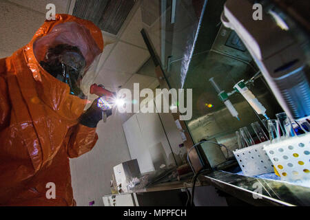 Sgt. Koran Williams mit 21 Waffen der New Jersey National Guard von Mass Destruction-Civil Support Team, untersucht eine simulierte Lab Website bei einer gemeinsamen Übung mit den Mitgliedern der Monmouth County Hazmat Team in Fort Monmouth, New Jersey, April 6, 2017. Das 21 WMD-CST ist eine gemeinsame Einheit aus New Jersey National Guard Soldaten und Piloten, deren Aufgabe es ist, die zivilen Autoritäten durch die Identifizierung von chemischen, biologischen, radiologischen und nuklearen Stoffen entweder in man-made oder Naturkatastrophen. (New Jersey National Guard Foto von Mark C. Olsen/Freigegeben) Stockfoto