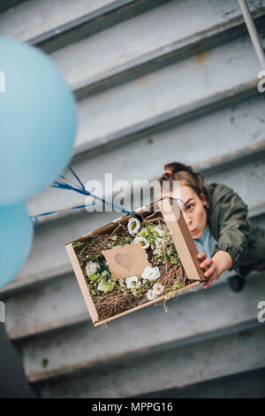 Frau senden in Karton mit Ballons Stockfoto