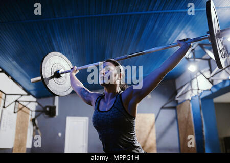 Frau heben Langhantel im Fitness-Studio Stockfoto