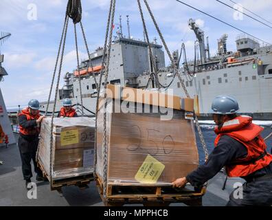 170403-N-RM689-332 SOUTH CHINA SEA (3. April 2017) Segler an Bord der Arleigh-Burke-Klasse geführt-Zerstörer USS Wayne E. Meyer (DDG-108) Führer Fracht von Lewis und Clark-Klasse Trockenfracht Schiff USNS Cesar Chavez (T-AKE-14) während der Auffüllung auf See. Wayne E. Meyer ist auf eine regelmäßige Westpazifik Bereitstellung mit der Carl Vinson Carrier Strike Group als Teil der US-Pazifikflotte geleitete Initiative U.S. verlängern 3. Flotte-Befehl und Kontrollfunktionen in der Indo-Asien-Pazifik-Region. US Navy Flugzeugträger Streik Gruppen haben routinemäßig die Indo-Asien-Pazifik für Mo patrouillierten. Stockfoto