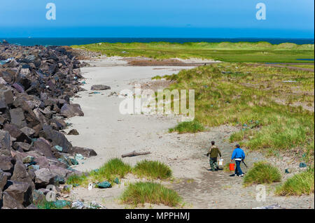 Warrenton, Virginia, USA - 30. Mai 2014: Zwei Männer mit Fanggeräten Spaziergang entlang des South jetty Wand des Columbia River auf der Oregon Küste. Stockfoto