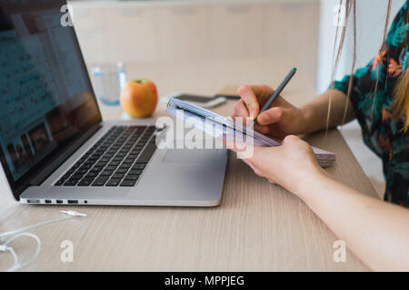 In der Nähe von Frau zu Hause mit Laptop und Notizen Stockfoto