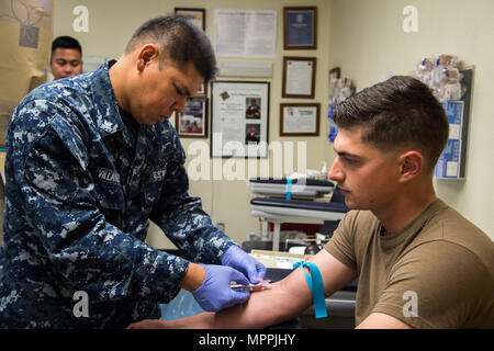 170408-N-CF 658-032 (08.04.2017) Hospital Corpsman 3. Klasse Mark Villanueva, ein San Diego Eingeborener, zeichnet Blut auf Constructionman 3. Klasse Brody Phillips, ein Eingeborener von Murrieta, Calif. und Mitglied der Amphibischen Bau Bataillon ein. HM3 Villanueva Bemühungen, die medizinische Bereitschaft von Matrosen in der Flotte dienen. (U.S. Marine Foto: Mass Communication Specialist 2. Klasse Amanda A. Hayes/Freigegeben) Stockfoto