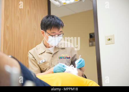 170408-N-OS 584-021 Coronado, Kalifornien (8. April 2017) Lieutenant Commander Youngseok Seo, zur Marine Air Station Branch Klinik zugewiesen, führt regelmäßige zahnmedizinische Prüfung auf Lt.Cmdr. Dustin Burton der Naval Meteorologie und Ozeanographie finden Aktivität 1994 für seine jährliche medizinische Physischen. (U.S. Marine Foto von Mass Communication Specialist 1. Klasse Jimmie Crockett/Freigegeben) Stockfoto