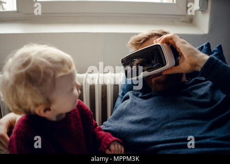 Vater und Sohn spielen mit VR-Brille zu Hause Stockfoto