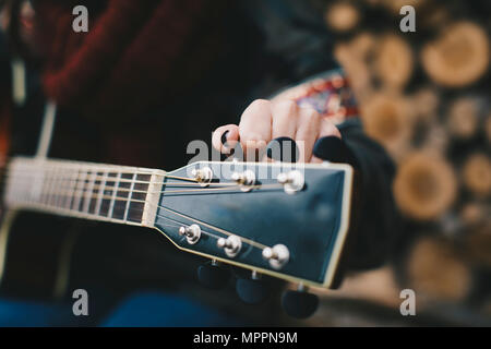 Junge Frau tuning Gitarre, close-up Stockfoto