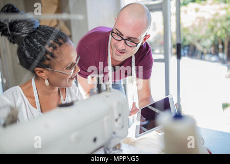 Fashion Designer zeigen Tablet im Studio zu Näherin Stockfoto