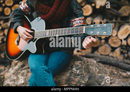 Junge Frau tuning Gitarre im Freien, Teilansicht Stockfoto