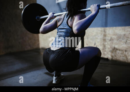 Frau heben Langhantel im Fitness-Studio Stockfoto