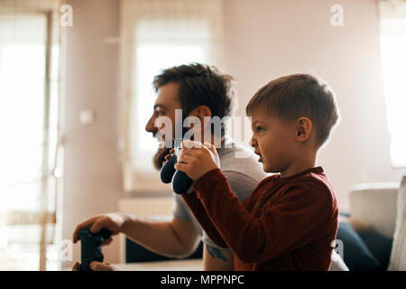 Little Boy spielen computer spiel mit seinem Vater zu Hause Stockfoto