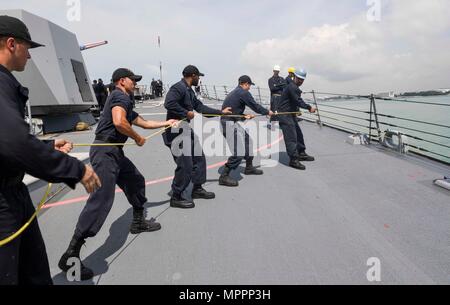 170404-N-RM689-066 Singapur (4. April 2017) Segler Haul in Linie auf dem Vorschiff beim Meer und Anker Detail an Bord der Arleigh-Burke-Klasse geführte Flugkörper Zerstörer USS Wayne E. Meyer (DDG-108) als das Schiff bereitet, am Changi Naval Base, Singapur festmachen. Wayne E. Meyer ist auf eine regelmäßige Westpazifik Bereitstellung mit der Carl Vinson Carrier Strike Group als Teil der US-Pazifikflotte geleitete Initiative U.S. verlängern 3. Flotte-Befehl und Kontrollfunktionen in der Indo-Asien-Pazifik-Region. US Navy Flugzeugträger Streik Gruppen haben routinemäßig die Indo-Asien-Pazifik für patrouillierten. Stockfoto