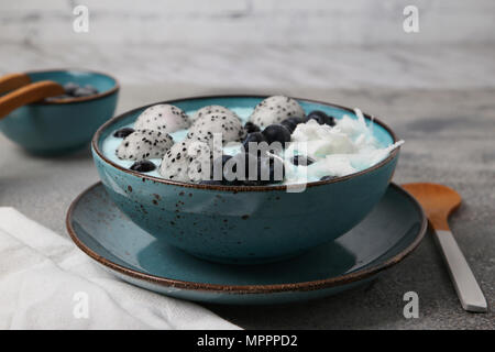 Blau smoothie Schüssel mit Kokosraspeln, Blaubeeren und Drachenfrucht Kugeln Stockfoto