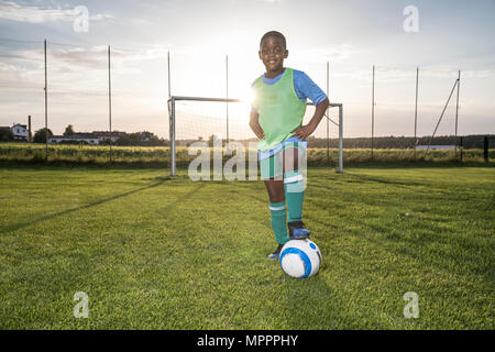 Portrait von selbstbewussten jungen Fußballspieler mit Ball am Fußballplatz Stockfoto