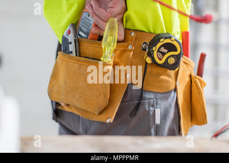 Nahaufnahme der Bauarbeiter mit Werkzeuggürtel Stockfoto