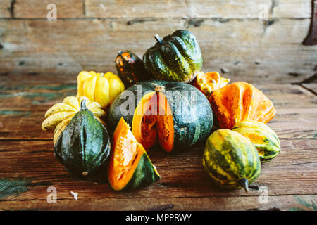 In Scheiben geschnitten und ganze Kürbisse auf Holz Stockfoto