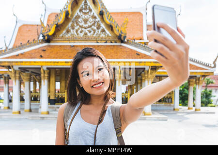 Thailand, Bangkok, Portrait von lächelnden Tourist, selfie mit Smartphone Stockfoto